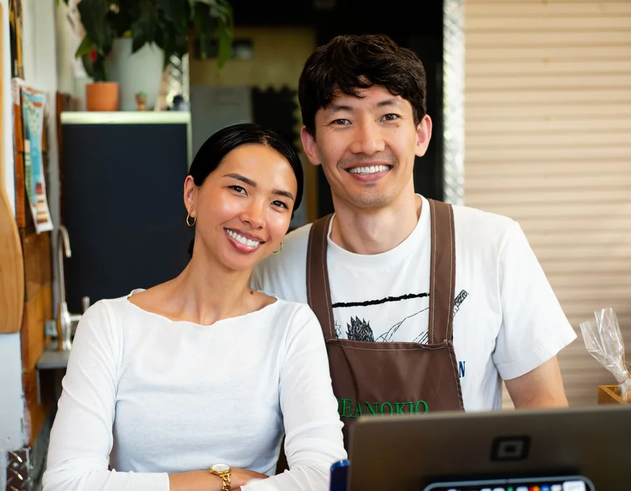 Two people standing together behind a café counter